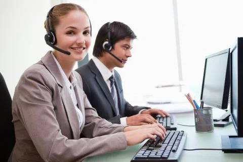 Smiling office workers using computers Stock Photos
