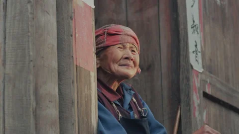 A smiling old man sitting in front of his house in rural Sichuan,  China Stock Footage 141771917