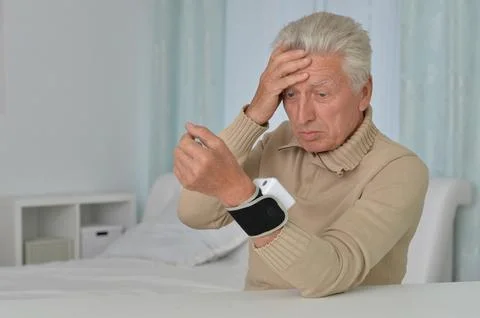Smiling old man using automatic carpal tonometer in hospital Stock Photos