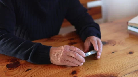 Smiling old man using smartphone while sitting on couch. Stock Footage 165172720