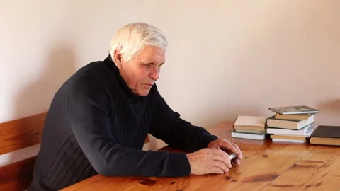 Smiling old man using smartphone while sitting on couch. Stock Footage 165173361