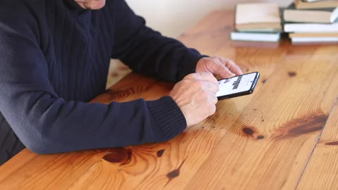 Smiling old man using smartphone while sitting on couch. Stock Footage 165173666