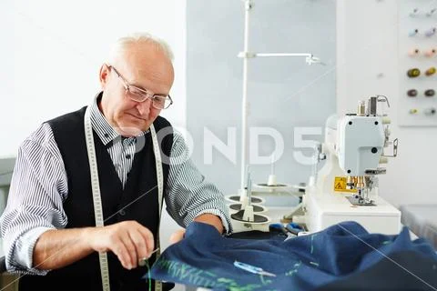 Smiling Old Man Working In Tailoring