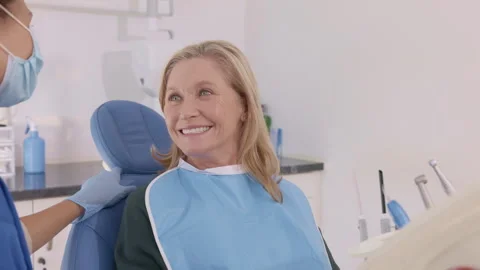 Smiling old woman looking at camera at dental clinic Stock Footage 336576487
