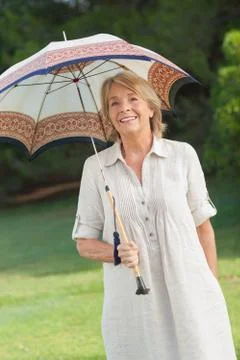 Smiling older woman holding umbrella Stock Photos