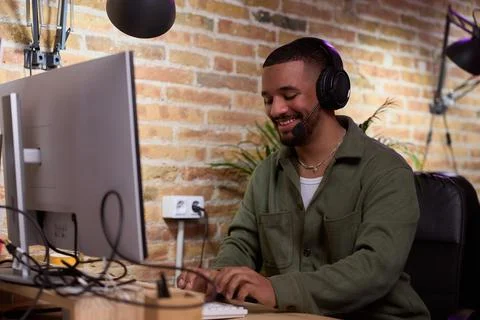 Smiling operator with headset working on computer in modern office Stock Photos