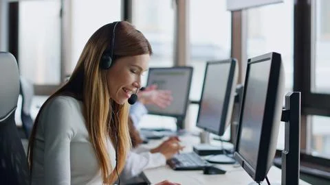 Smiling operator typing computer in data center. Joyful woman assistant at work. 스톡 사진