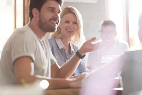 Smiling parents talking and gesturing to daughter at cafe Stock Photos