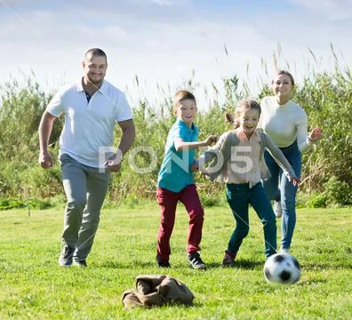 Smiling parents with two kids playing soccer Stock Image #150724066