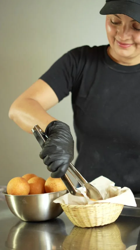Smiling pastry chef serving cheese buns or bunuelos in a basket ready Stock Footage 286168715