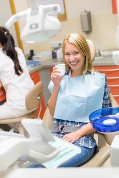 Smiling patient sit dental chair modern surgery Stock Photos