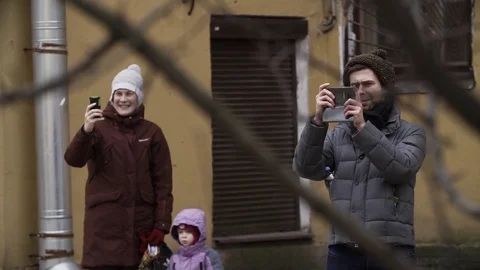 Smiling people taking photo using smartphone at city street Stock Footage 84931487