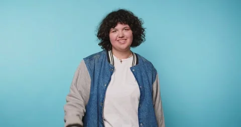 Smiling person shows different hand signs in front of blue background in a .. Vídeo Stock 328247200