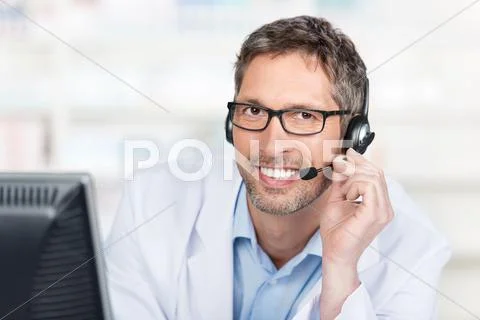 Smiling pharmacist wearing headset at counter Stock Photos