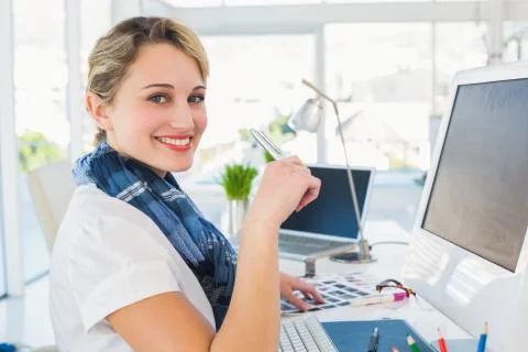 Smiling photo editor using computer Stock Photos