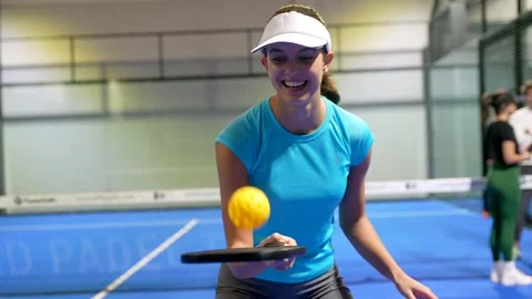 Smiling pickleball player juggling a yellow ball Stock Footage 329549585
