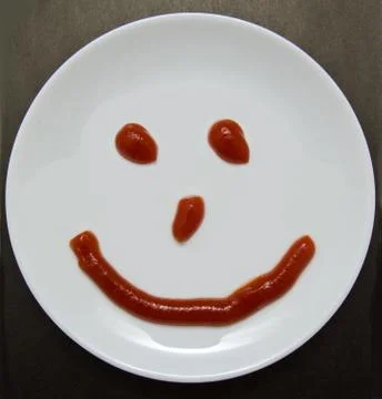 A smiling plate on a dark background Stock Photos