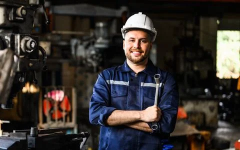 Smiling portrait of mechanical technician checking and inspecting machine Foto stock