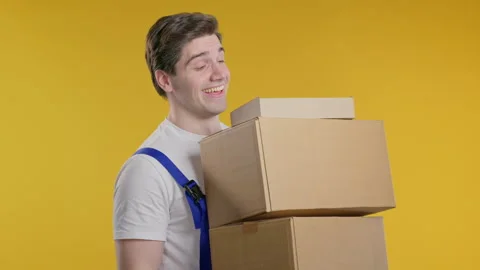 Smiling postal courier, porter man with parcels boxes. Happy handyman delivering 스톡 동영상 277539528