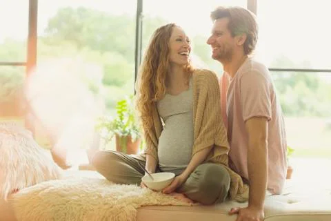 Smiling pregnant couple eating and talking Stock Photos