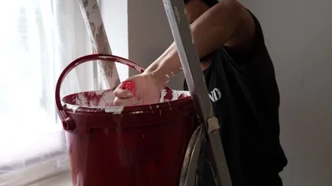 Smiling Professional Painter Dipping Roller into Red Paint Bucket Home Reno.. Video stock 347724627