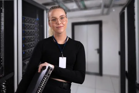 Smiling professional technician holding network equipment in a modern server Stock Photos