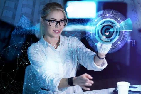 Smiling programmer touching the modern transparent screen while working Stock-Fotos