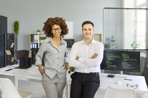 Smiling programmers and developers in modern office, teamwork with coding Stock Photos