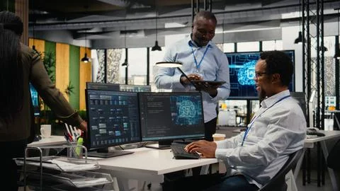 Smiling programmers working in AI startup train predictive models Foto stock