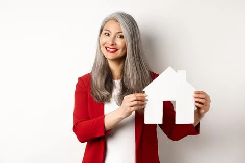 Smiling real estate agent showing paper house clipboard, broker working with Stock Photos