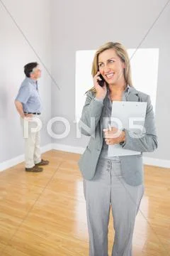 Smiling realtor calling someone with her mobile phone Stock Photos