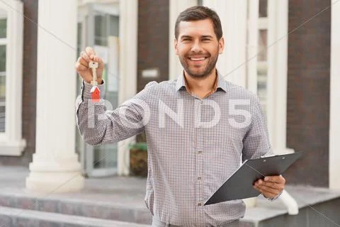 Smiling realtor standing outside modern house Stock Photos