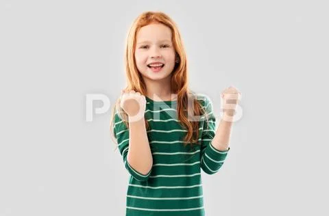 Smiling red haired girl celebrating success Stock Photos