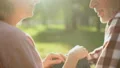 Smiling retired couple relaxing in park, holding hands and talking about love HD Footage