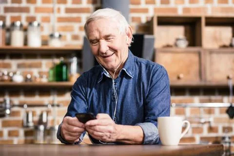 Smiling retired man using his smartphone Stock Photos