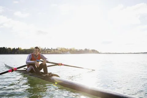 Smiling rower in scull on river Stock Photos