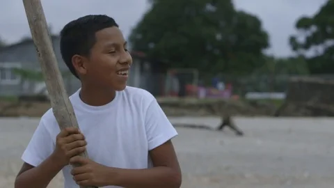 Smiling rural boy playing cricket Stock Footage 70883336