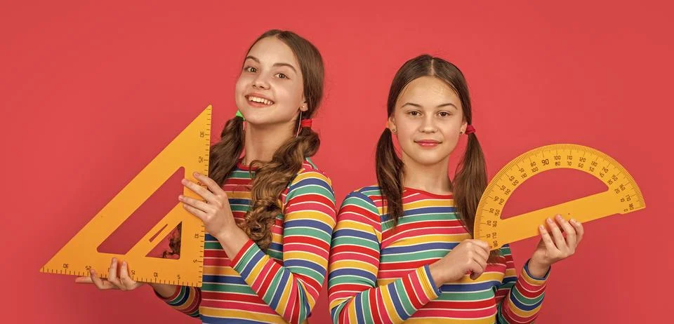 Smiling school students hold math tool of triangle and protractor Stock Photos
