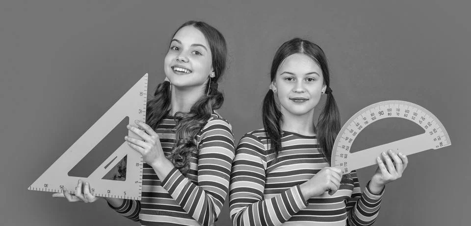 Smiling school students hold math tool of triangle and protractor Stock Photos