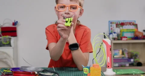 Smiling schoolboy shows square bee made with 3d pen in classroom Stockbeeldmateriaal 322007657