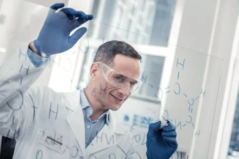 Smiling scientist figuring out new chemical formula 库存照片