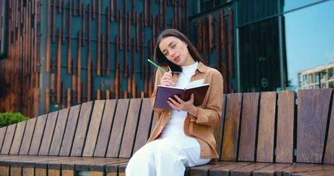 Smiling self employed female making phone call on mobile phone and taking notes Stock Footage 316314579