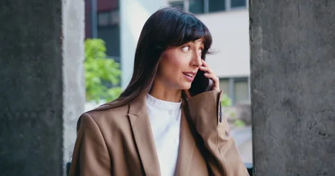 Smiling self employed woman making phone call on mobile phone and taking notes w Stock Footage 330298606