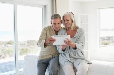 Smiling senior couple using a digital tablet Stock Photos