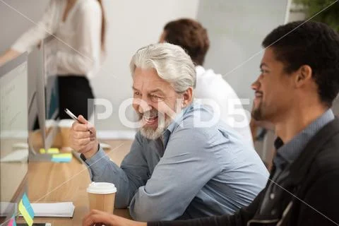 Smiling senior employee discussing email with african colleague Stock Photos