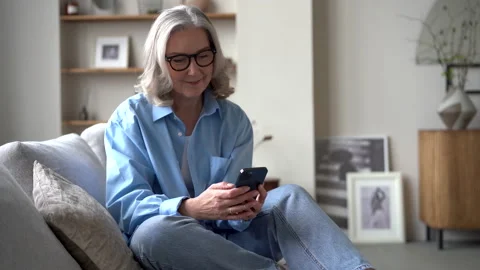 Smiling senior lady using smartphone texting message, enjoying communication. Stock Footage 194950515