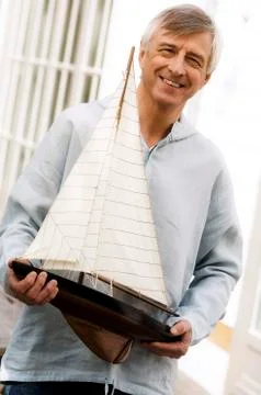 Smiling senior man holding a model boat outdoors Stock Photos