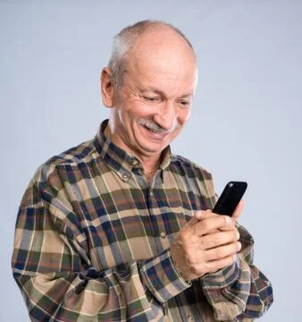 Smiling senior man in shirt talking on the mobile phone 写真素材
