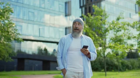 Smiling senior man texting on cell phone outside Stock Footage 135465591