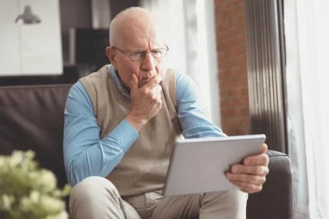 Smiling senior man using a digital tablet Stock Photos